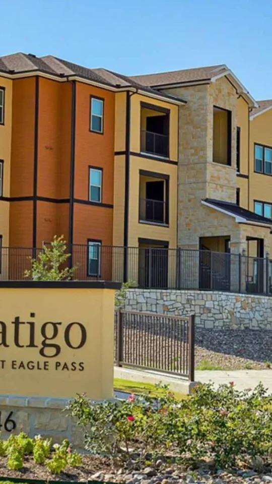 the sign for latigo apartments is in front of a building at The Latigo at Eagle Pass